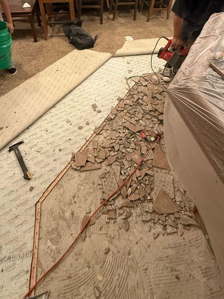 Before: old tile being hammered off the basement slab in Canal Place by Geist