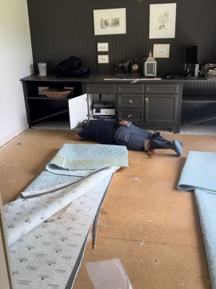 Before: old carpet and pad pulled back in a Zionsville home office