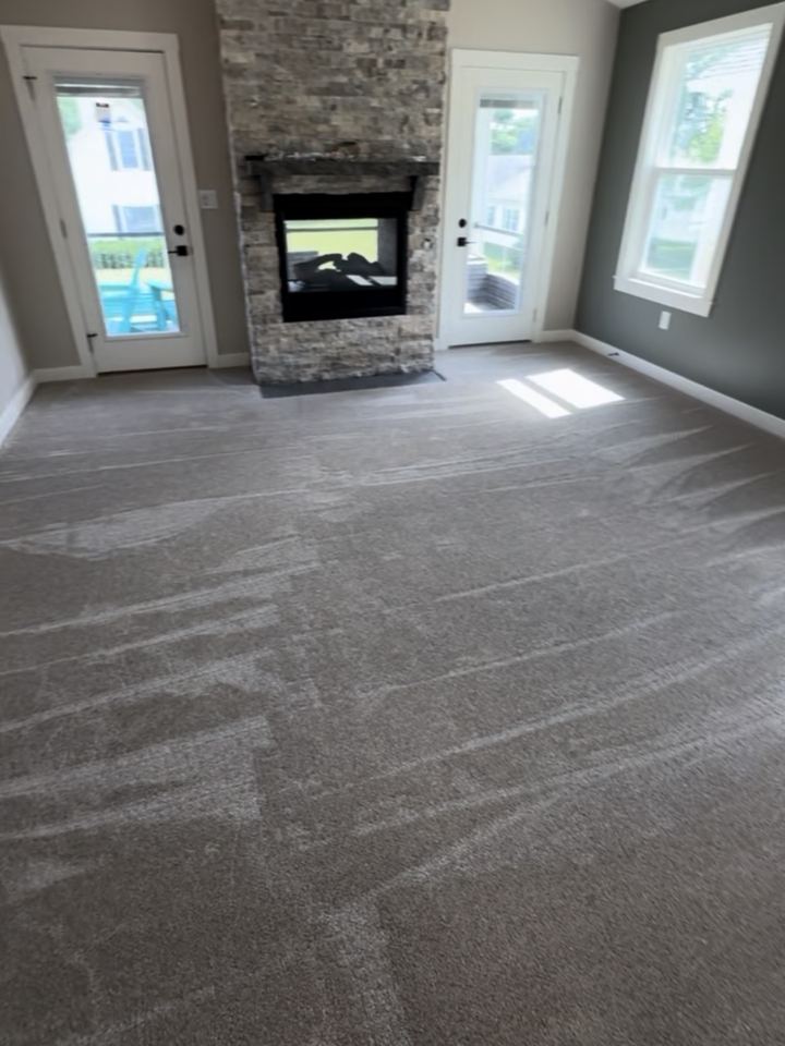 After: wall-to-wall carpet around the two-sided stone fireplace, vacuum lines fresh, Cicero