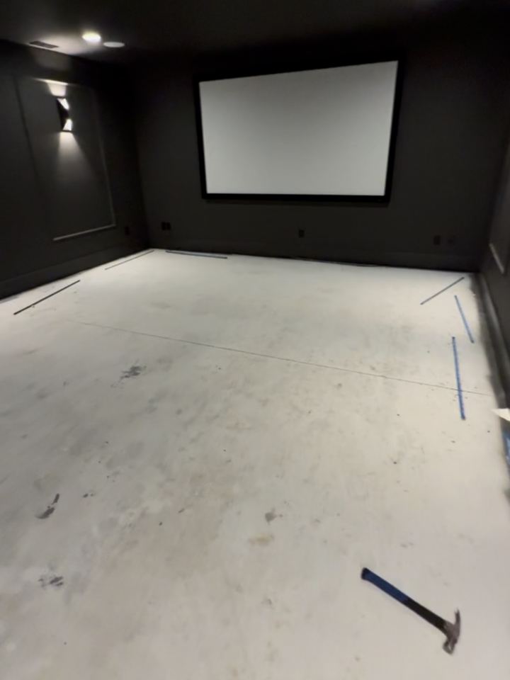 Before: bare concrete slab with tack strip laid, facing the theater screen, Westfield